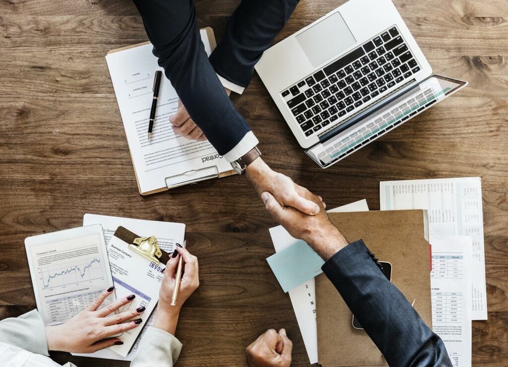 people in suits shaking hands as if agreeing on a translation management deal